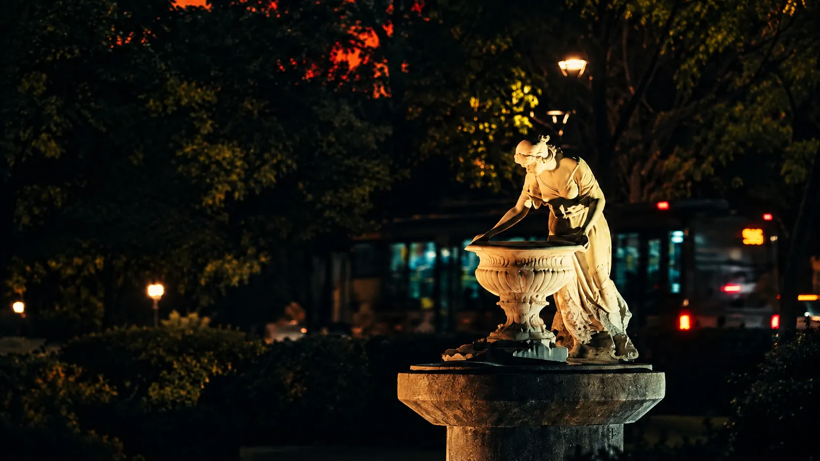 Fonte iluminada em cenário urbano noturno